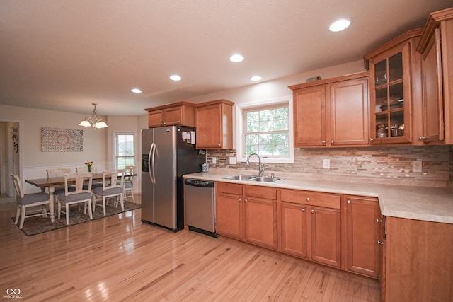 60 Bittersweet Ct, Seymour, IN 47274 - kitchen with a sink, stainless steel appliances, light wood-style floors, brown cabinets, and backsplash