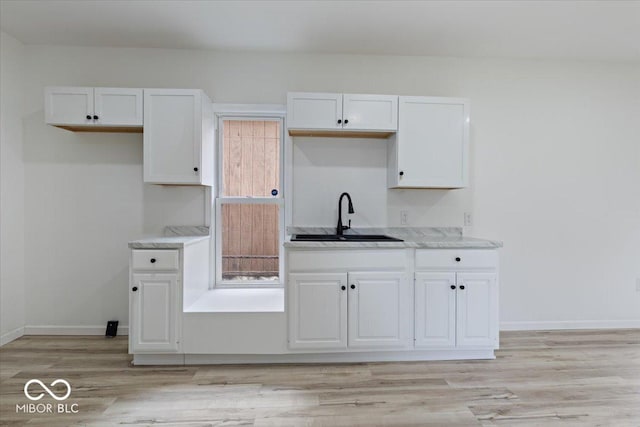 3218 N 24th St, Terre Haute, IN 47804 - kitchen with a sink, white cabinetry, light wood-style floors, and baseboards