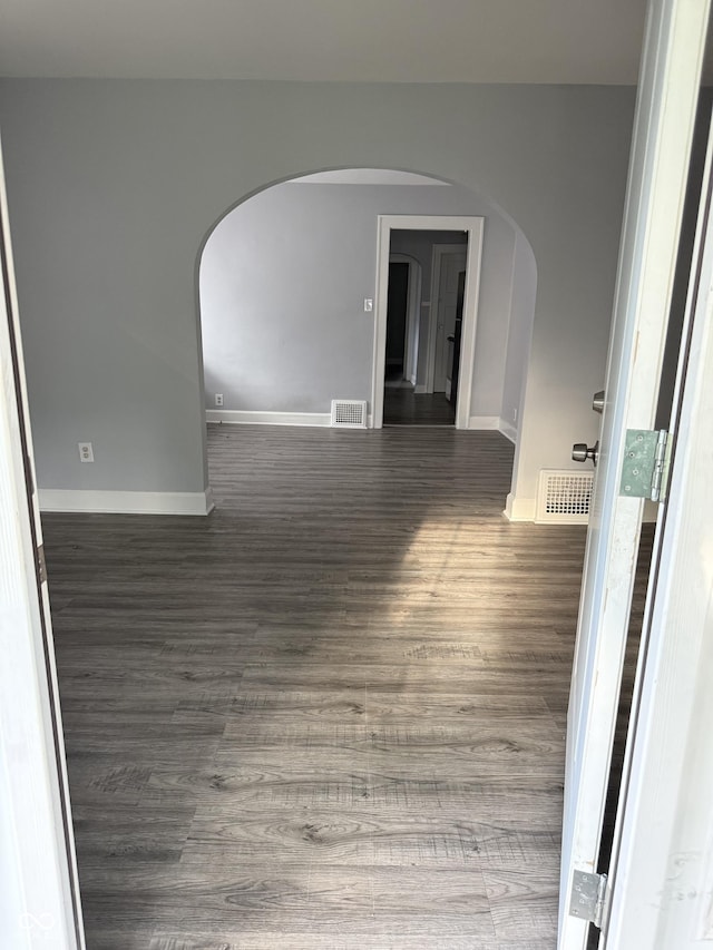 701 N Gladstone Ave, Indianapolis, IN 46201 - unfurnished room with arched walkways, baseboards, and wood finished floors