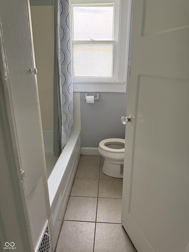 701 N Gladstone Ave, Indianapolis, IN 46201 - bathroom with tile patterned floors, toilet, shower / tub combo, and baseboards