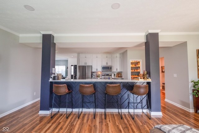 935 Northwich Ave, Westfield, IN 46074 - kitchen featuring stainless steel appliances, a peninsula, wood finished floors, and crown molding