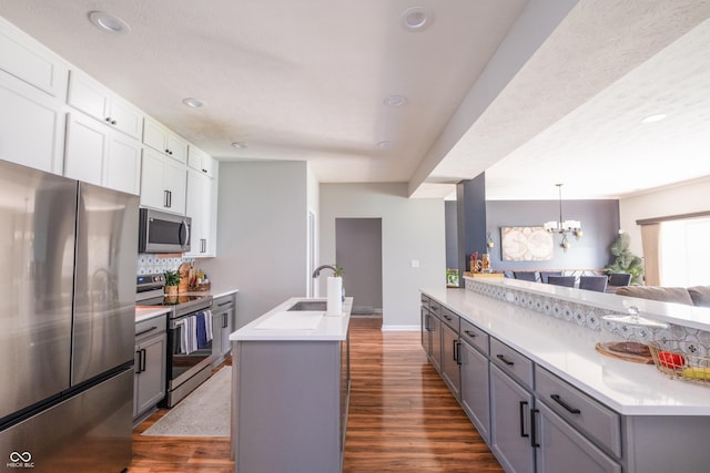 935 Northwich Ave, Westfield, IN 46074 - kitchen featuring stainless steel appliances, a sink, dark wood finished floors, light countertops, and backsplash