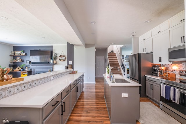 935 Northwich Ave, Westfield, IN 46074 - kitchen featuring stainless steel appliances, a sink, dark wood-type flooring, an island with sink, and light countertops