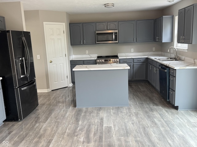 8939 Newchurch Blvd, Indianapolis, IN 46231 - kitchen with stainless steel appliances, a sink, gray cabinetry, light countertops, and light wood-style floors