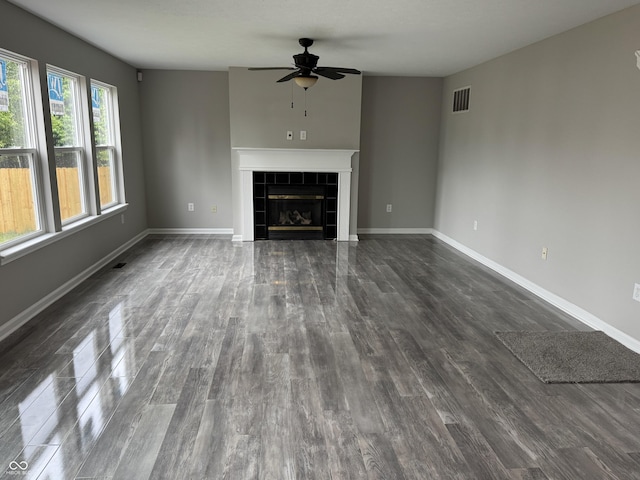 8939 Newchurch Blvd, Indianapolis, IN 46231 - unfurnished living room featuring ceiling fan, dark wood-style flooring, a tile fireplace, and baseboards