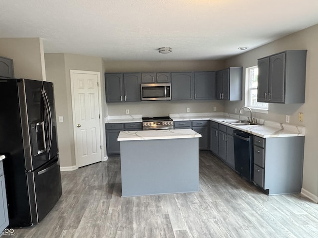 8939 Newchurch Blvd, Indianapolis, IN 46231 - kitchen featuring stainless steel appliances, a sink, gray cabinets, light wood finished floors, and a center island