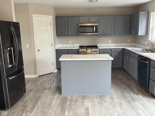 8939 Newchurch Blvd, Indianapolis, IN 46231 - kitchen with appliances with stainless steel finishes, a sink, gray cabinets, light stone counters, and wood finished floors