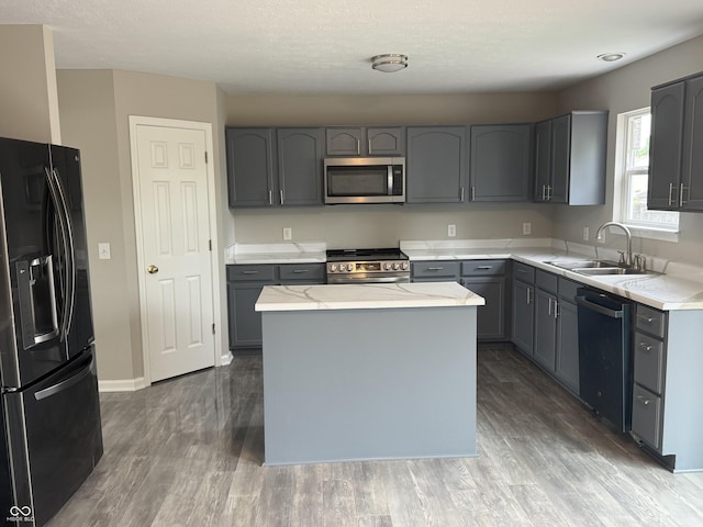 8939 Newchurch Blvd, Indianapolis, IN 46231 - kitchen featuring stainless steel appliances, a sink, gray cabinetry, wood finished floors, and a center island