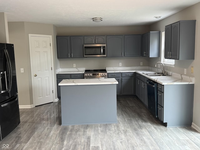 8939 Newchurch Blvd, Indianapolis, IN 46231 - kitchen featuring appliances with stainless steel finishes, a sink, gray cabinetry, and wood finished floors