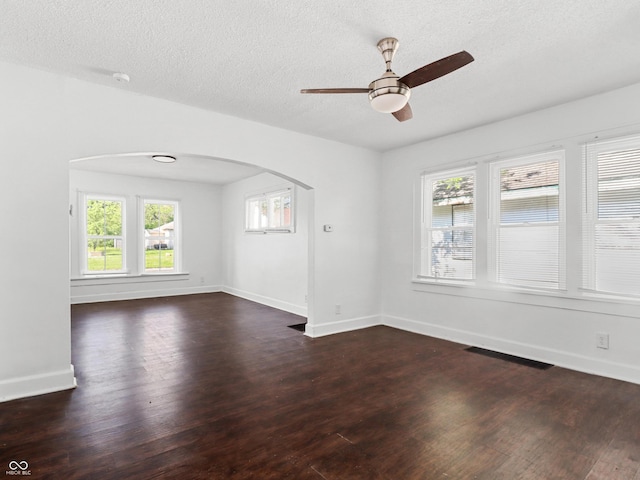 1209 W 22nd St, Anderson, IN 46016 - spare room featuring arched walkways, a ceiling fan, dark wood-type flooring, healthy amount of natural light, and a textured ceiling