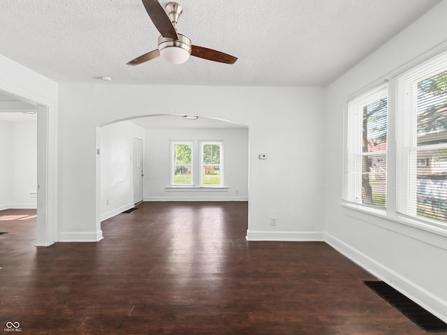 1209 W 22nd St, Anderson, IN 46016 - spare room featuring arched walkways, a textured ceiling, wood finished floors, ceiling fan, and baseboards