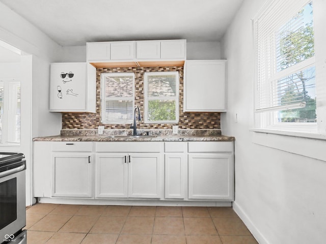 1209 W 22nd St, Anderson, IN 46016 - kitchen with a sink, stainless steel electric stove, backsplash, white cabinetry, and light tile patterned floors