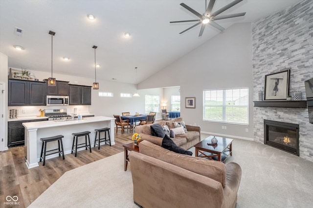5304 Maywood Dr, Whitestown, IN 46075 - living room with healthy amount of natural light, high vaulted ceiling, light wood-style floors, a ceiling fan, and a fireplace