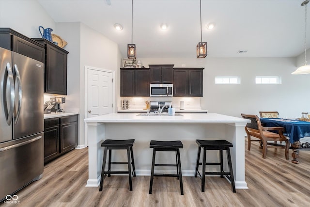 5304 Maywood Dr, Whitestown, IN 46075 - kitchen featuring stainless steel appliances, light countertops, a kitchen bar, and light wood-style flooring