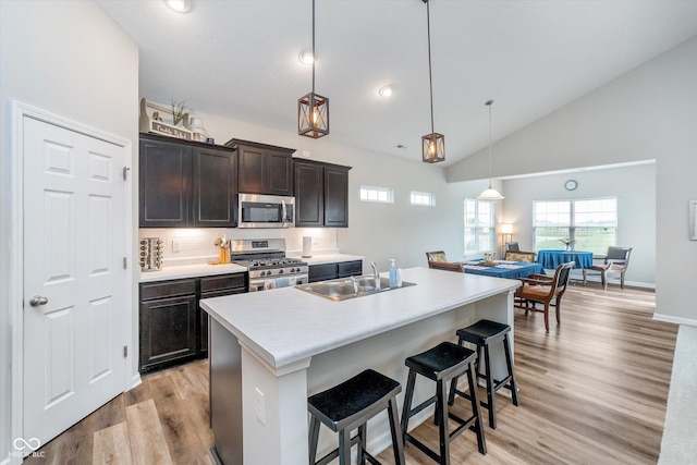 5304 Maywood Dr, Whitestown, IN 46075 - kitchen with appliances with stainless steel finishes, a sink, light wood-style flooring, light countertops, and a kitchen bar