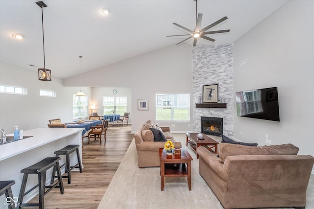 5304 Maywood Dr, Whitestown, IN 46075 - living area with light wood finished floors, high vaulted ceiling, ceiling fan, a stone fireplace, and recessed lighting