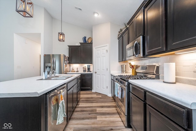 5304 Maywood Dr, Whitestown, IN 46075 - kitchen featuring appliances with stainless steel finishes, a sink, lofted ceiling, light wood finished floors, and light countertops