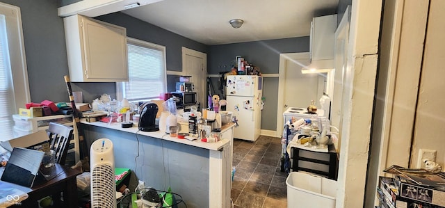 315 S Rural St, Indianapolis, IN 46201 - kitchen featuring freestanding refrigerator, white cabinetry, light countertops, a peninsula, and black microwave