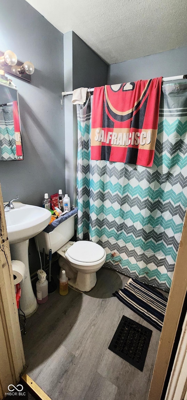 315 S Rural St, Indianapolis, IN 46201 - full bathroom featuring wood finished floors, toilet, a textured ceiling, and a shower with curtain