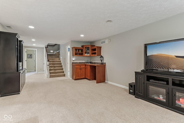 10759 Sawgrass Dr, Fishers, IN 46037 - kitchen featuring brown cabinets, glass insert cabinets, light carpet, and recessed lighting
