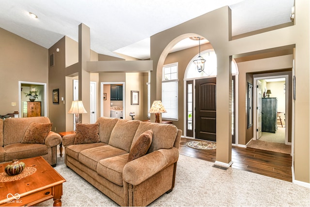 10759 Sawgrass Dr, Fishers, IN 46037 - living area with wood-type flooring, arched walkways, and high vaulted ceiling