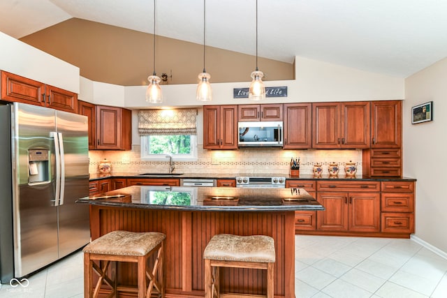 10759 Sawgrass Dr, Fishers, IN 46037 - kitchen with stainless steel appliances, lofted ceiling, tasteful backsplash, a breakfast bar area, and a kitchen island