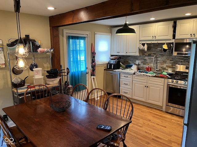 230 E Poplar St, Danville, IN 46122 - kitchen with a sink, stainless steel appliances, backsplash, light wood finished floors, and white cabinets