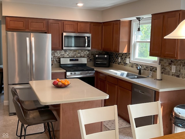 425 Bridgewater Ln S, Muncie, IN 47304 - kitchen featuring appliances with stainless steel finishes, a sink, a center island, tasteful backsplash, and a kitchen breakfast bar