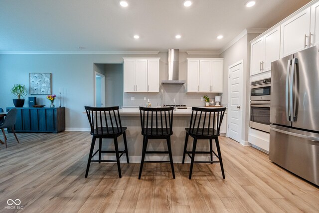 9741 Haughton Ln, Mccordsville, IN 46055 - kitchen with appliances with stainless steel finishes, wall chimney exhaust hood, ornamental molding, a center island, and a breakfast bar area
