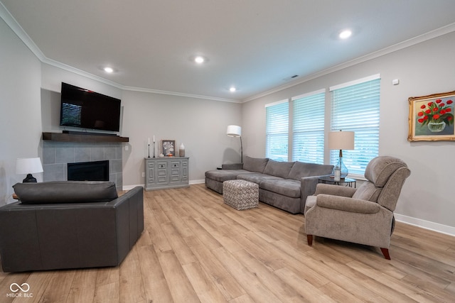 9741 Haughton Ln, Mccordsville, IN 46055 - living room featuring light wood finished floors, a tiled fireplace, ornamental molding, and recessed lighting