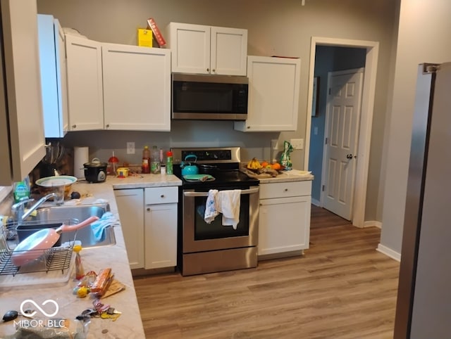 639 N Hamilton Ave, Indianapolis, IN 46201 - kitchen featuring appliances with stainless steel finishes, a sink, light countertops, and white cabinetry
