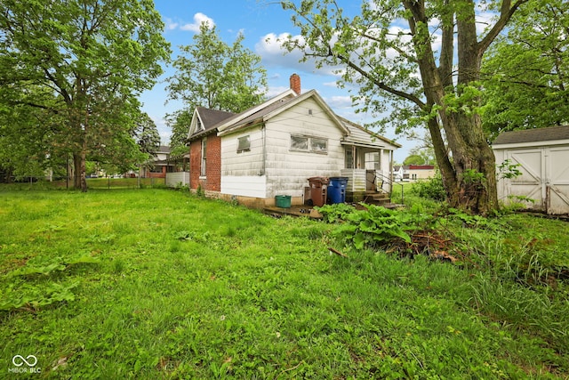 1514 W 2nd St, Marion, IN 46952 - rear view of house featuring a chimney and a lawn