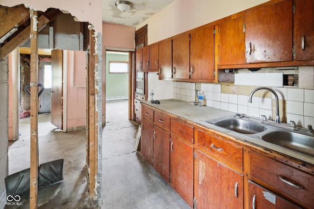 1514 W 2nd St, Marion, IN 46952 - kitchen with a sink, concrete floors, a baseboard radiator, decorative backsplash, and brown cabinets