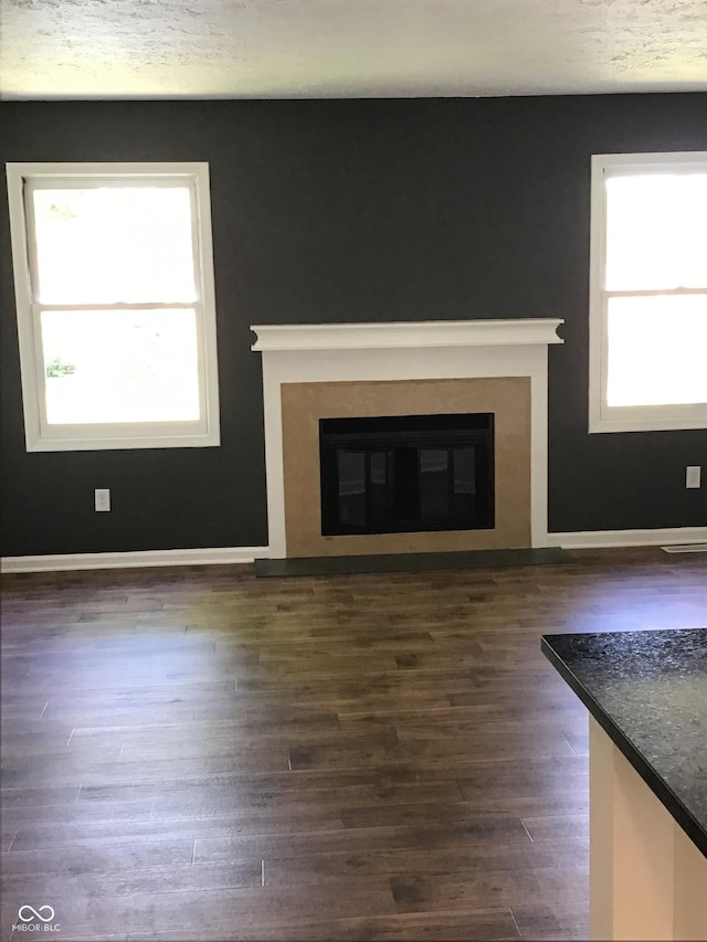 6070 Southbay Dr, Indianapolis, IN 46250 - unfurnished living room featuring a glass covered fireplace, dark wood-style floors, and baseboards