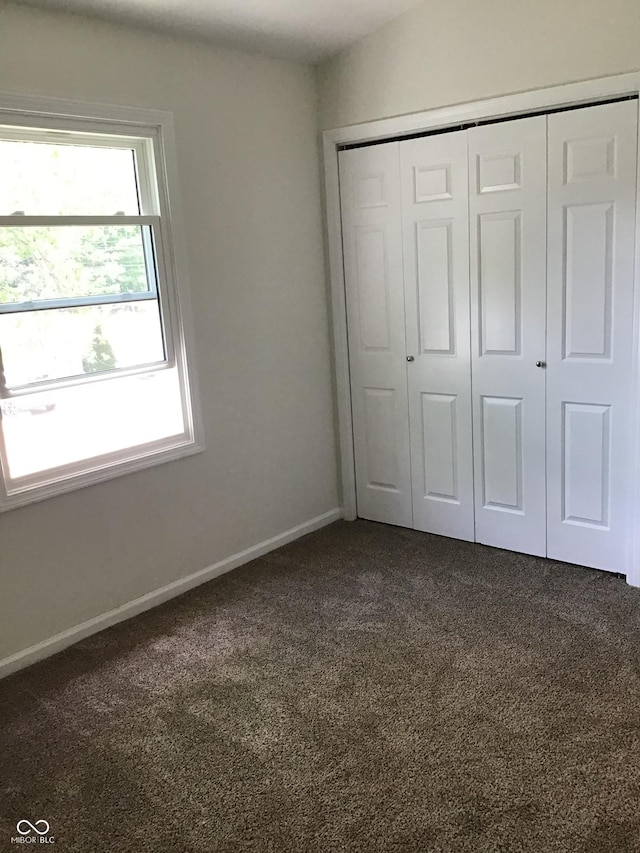 6070 Southbay Dr, Indianapolis, IN 46250 - unfurnished bedroom with dark carpet, a closet, and baseboards