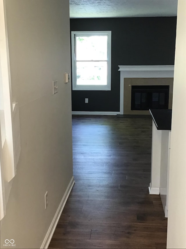 6070 Southbay Dr, Indianapolis, IN 46250 - unfurnished living room with dark wood finished floors, baseboards, and a glass covered fireplace