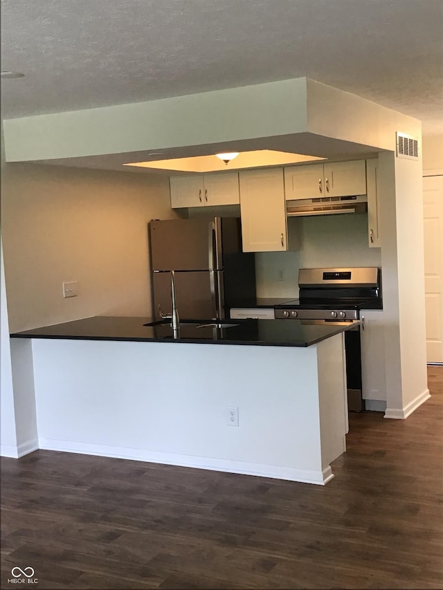 6070 Southbay Dr, Indianapolis, IN 46250 - kitchen featuring freestanding refrigerator, electric stove, under cabinet range hood, dark countertops, and dark wood-style flooring