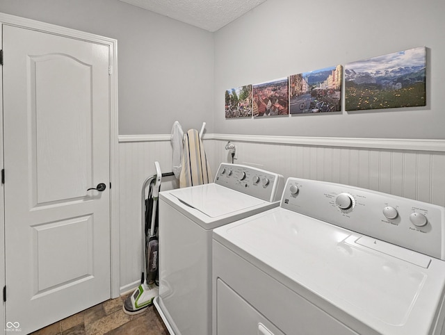 319 Mcintosh Ln, Westfield, IN 46074 - laundry room featuring independent washer and dryer, a wainscoted wall, a textured ceiling, and dark stone finish floors