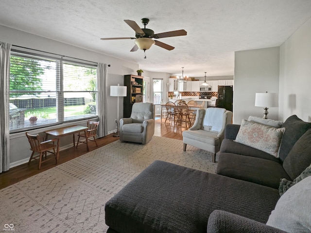 319 Mcintosh Ln, Westfield, IN 46074 - living room featuring a chandelier, ceiling fan, wood finished floors, and a textured ceiling