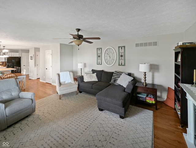 319 Mcintosh Ln, Westfield, IN 46074 - living area with light wood-type flooring, a ceiling fan, a textured ceiling, baseboards, and a chandelier