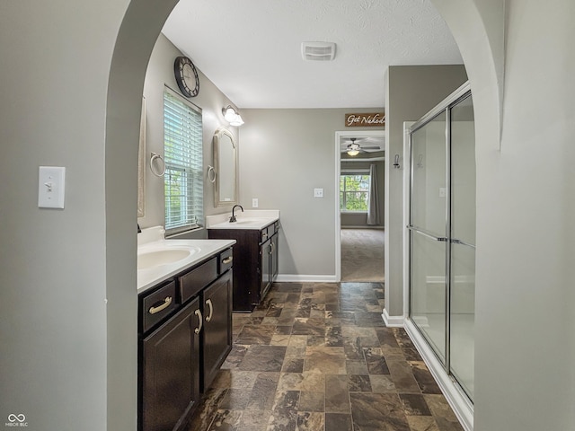 1843 Winchester Blvd, Avon, IN 46123 - full bathroom featuring a ceiling fan, stone finish floors, a shower stall, baseboards, and two vanities