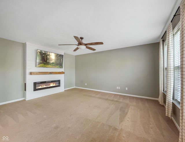 1843 Winchester Blvd, Avon, IN 46123 - unfurnished living room featuring a glass covered fireplace, carpet floors, a ceiling fan, and baseboards