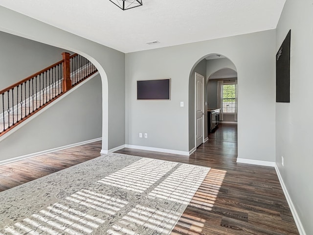 1843 Winchester Blvd, Avon, IN 46123 - unfurnished room featuring arched walkways, dark wood finished floors, and baseboards
