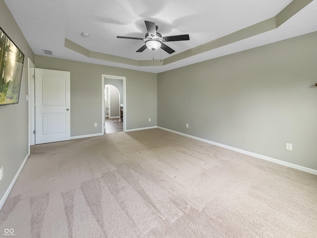 1843 Winchester Blvd, Avon, IN 46123 - unfurnished bedroom featuring a tray ceiling, arched walkways, carpet flooring, and baseboards