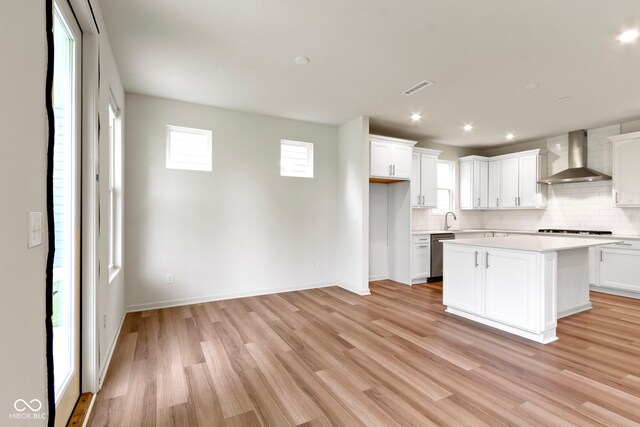 7248 Covington St, Lebanon, IN 46052 - kitchen featuring wall chimney range hood, tasteful backsplash, stainless steel dishwasher, light countertops, and plenty of natural light