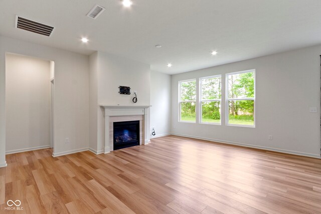 7248 Covington St, Lebanon, IN 46052 - unfurnished living room featuring light wood-type flooring, a glass covered fireplace, baseboards, and recessed lighting