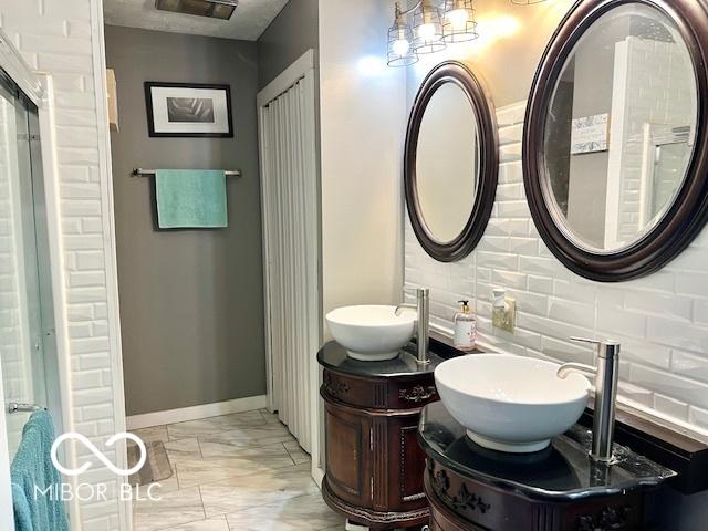 6774 S Becks Grove Rd, Freetown, IN 47235 - bathroom featuring marble finish floors, decorative backsplash, double vanity, and baseboards