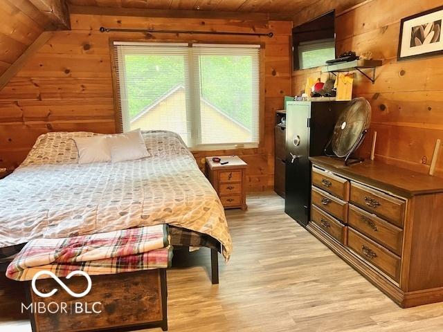 6774 S Becks Grove Rd, Freetown, IN 47235 - bedroom with wood ceiling, wooden walls, and light wood-style flooring
