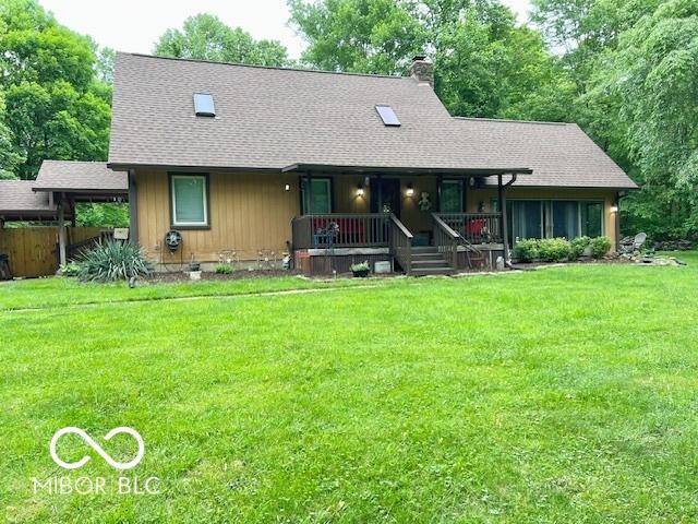 6774 S Becks Grove Rd, Freetown, IN 47235 - view of front of home with covered porch, a chimney, a front lawn, and roof with shingles