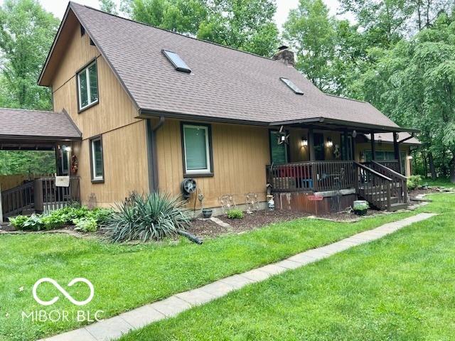 6774 S Becks Grove Rd, Freetown, IN 47235 - view of front facade with covered porch, a chimney, a front yard, and a shingled roof